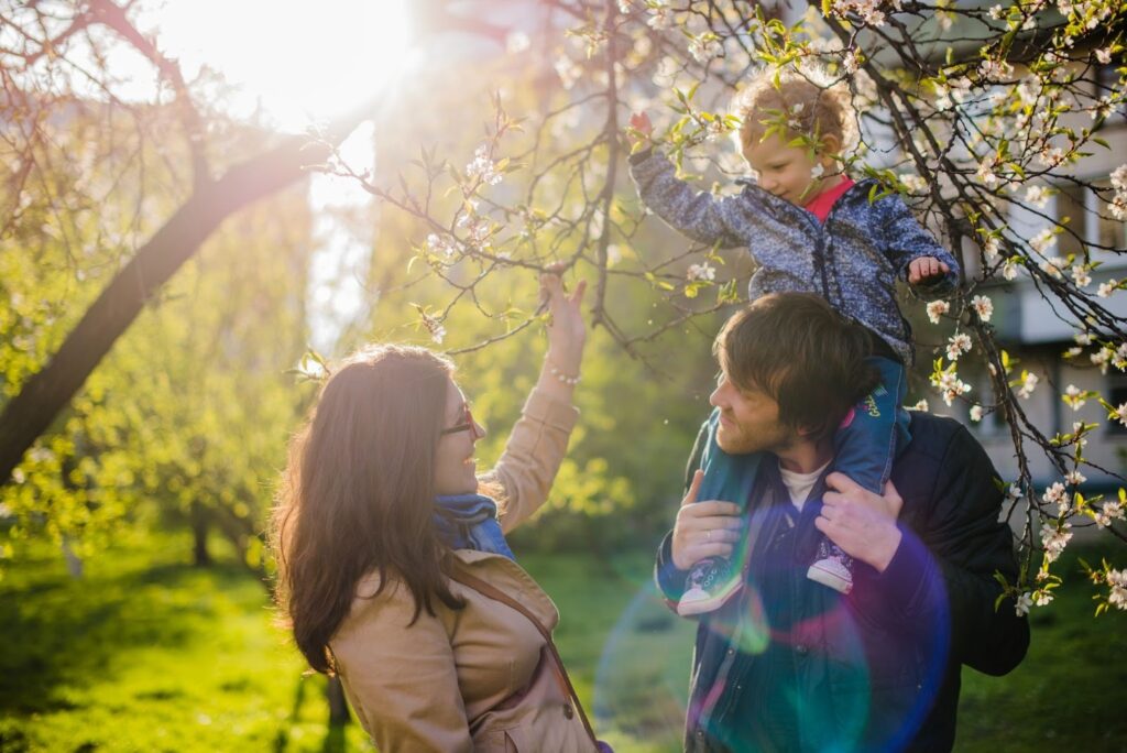 Parents se regardant, le père tenant son fils dans les épaules - Printemps