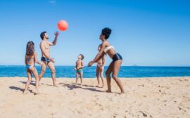 Famille jouant au ballon en bord de mer