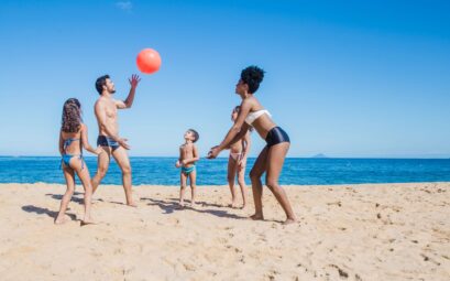 Famille jouant au ballon en bord de mer