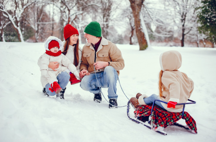 Famille avec enfants s'amusant à la luge